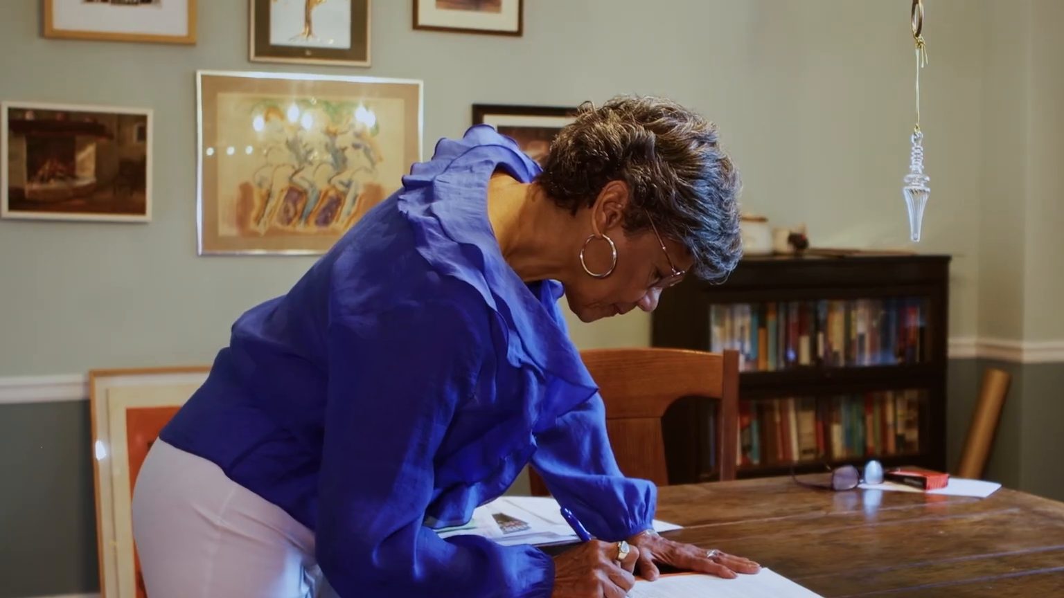 Sonia Manzano writing at a wooden table at home